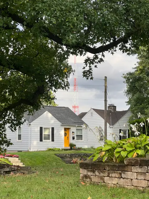 Steel giants looming over shingled roofs.